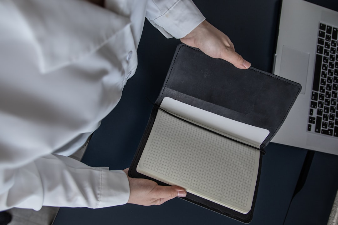 Designer's hand holds a sleek tablet displaying a high-resolution image of a modern living room, representing the future o...