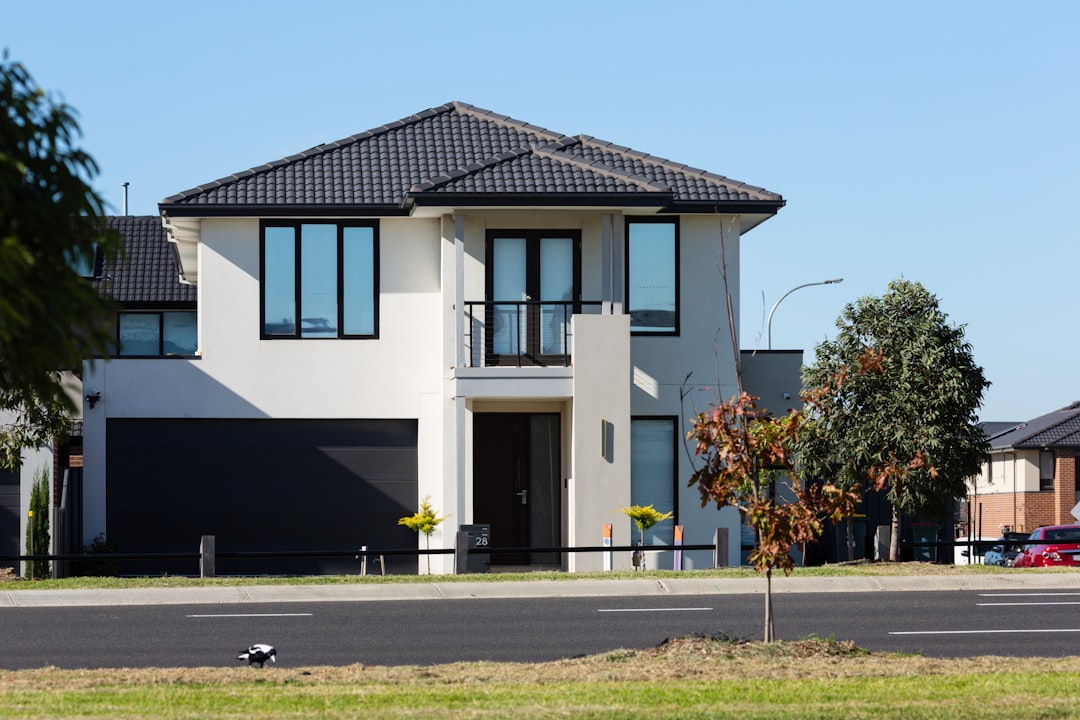 Skilled roofing contractor carefully installs new architectural shingles on a modern house, showcasing quality craftsmansh...