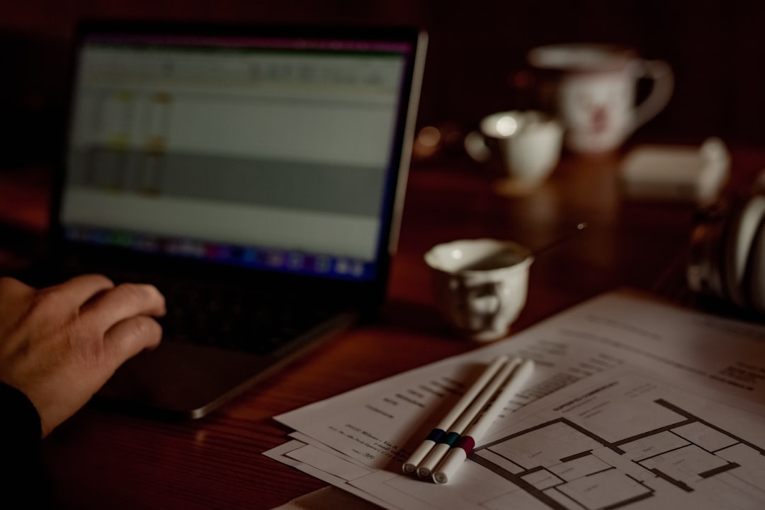 A close-up shot of a person's hands placing house keys onto a professional architectural blueprint, representing planning and maximizing home equity.
