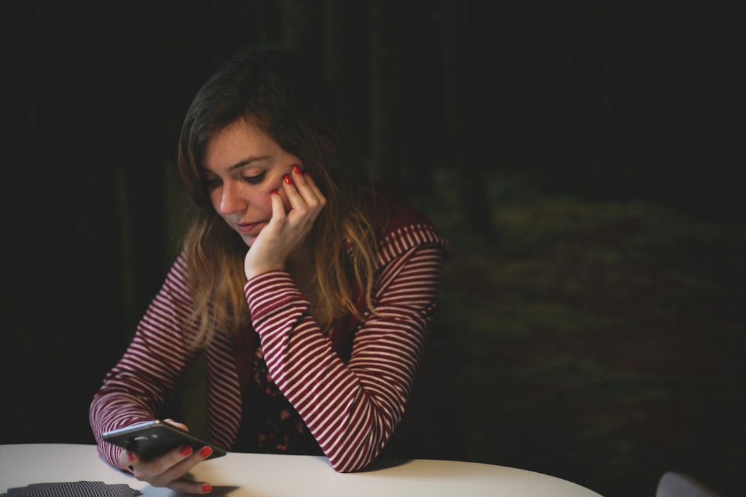 A homeowner sits at a kitchen table looking stressed while reviewing financial documents and a calculator, representing the overwhelming costs associated with selling a home.