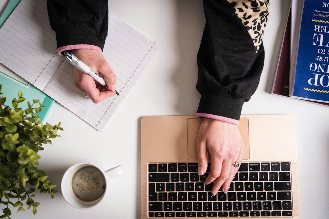 A professional rental owner meticulously curates their guest list by writing in a stylish notebook at a bright, minimalist desk.